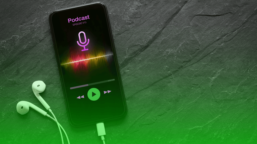 an iPhone with a headphone connected to it and a screen that is showing a Spotify podcast.