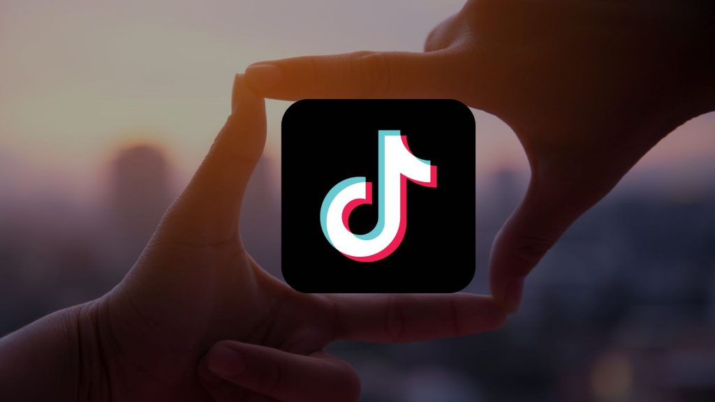 Hands highlighting the TikTok logo, which is the featured image of the blog 'How much does TikTok pay for Views in each country?