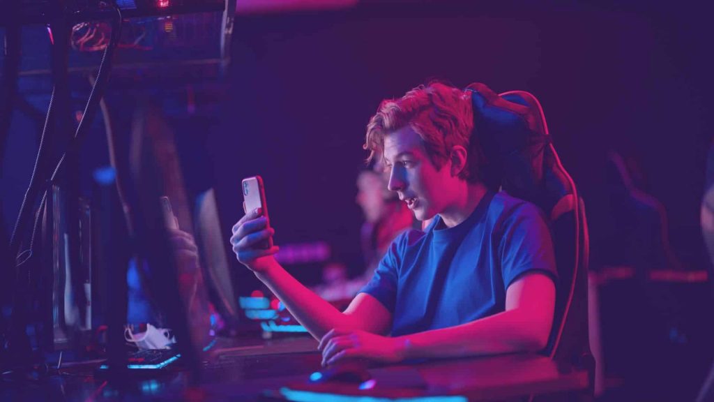 Young man playing on a PC in a gamer chair, featured image for a blog about 'How much Twitch pays in each country.'