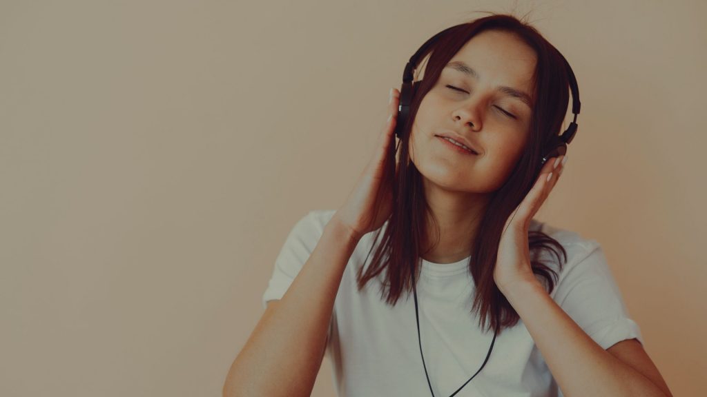 Young girl listening to music, featured image of an article about TikTok tips for artists