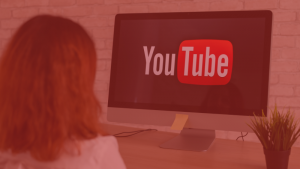 una mujer mirando una pantalla que muestra el logo de youtube, imagen destacada del blog sobre el youtube partner program