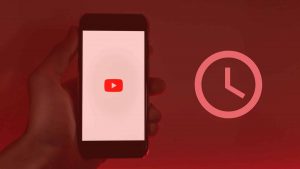 Phone with the YouTube logo next to a clock icon, featured image of the article 'How to get hours on YouTube to monetize.'