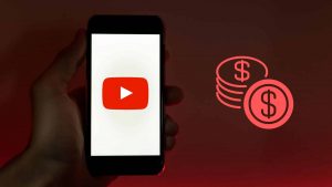 A phone displaying the YouTube logo alongside the image of some coins, main image of a text about the most profitable YouTube niches
