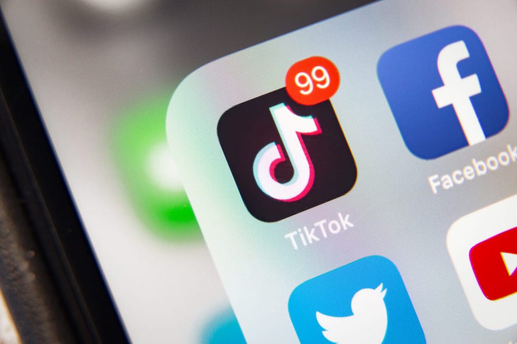 a phone screen zoomed on the TikTok app logo beside the Facebook app as a featured image in a blog post about How to get more followers on Tik Tok