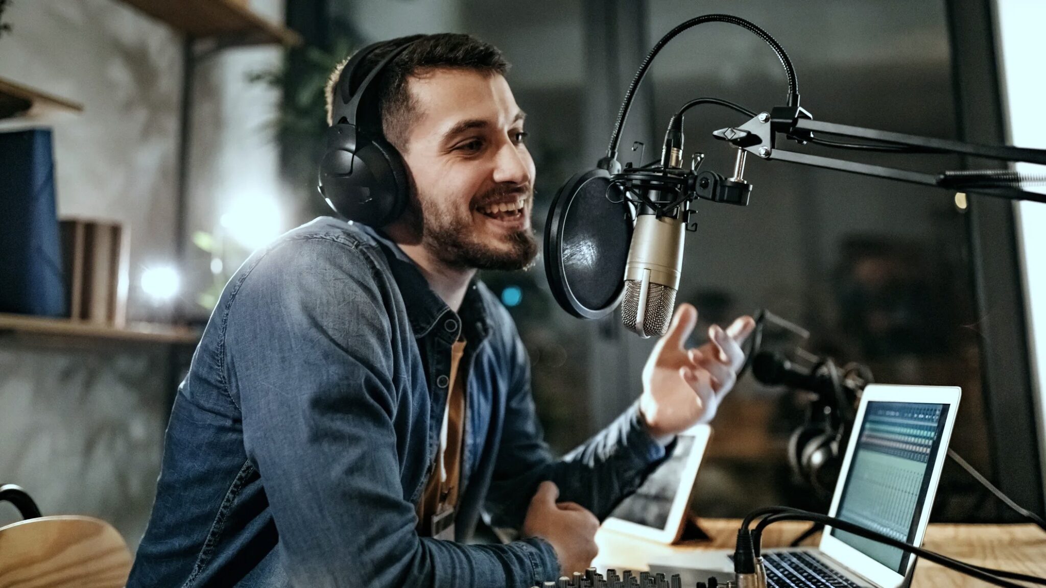 Man in front of microphone recording a podcast, talking about how to buy Spotify plays