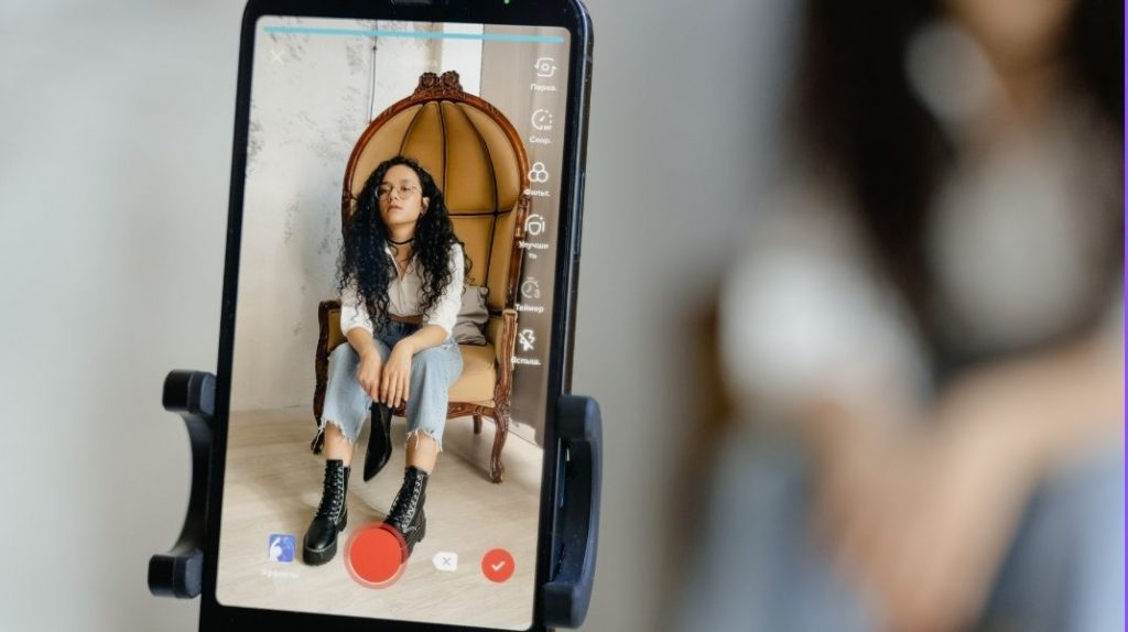 Smartphone filming a woman with TikTok editing program open